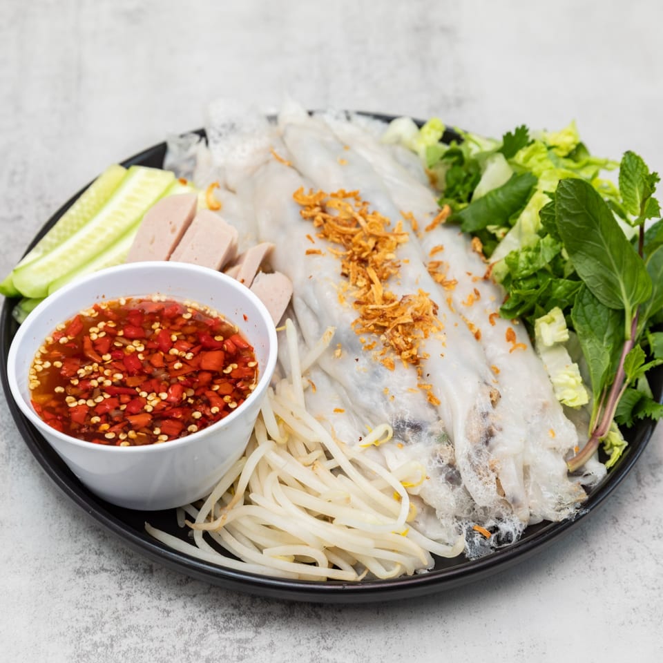 Steamed rice rolls with pork, cucumber, bean sprouts, herbs, and a spicy chili dipping sauce.